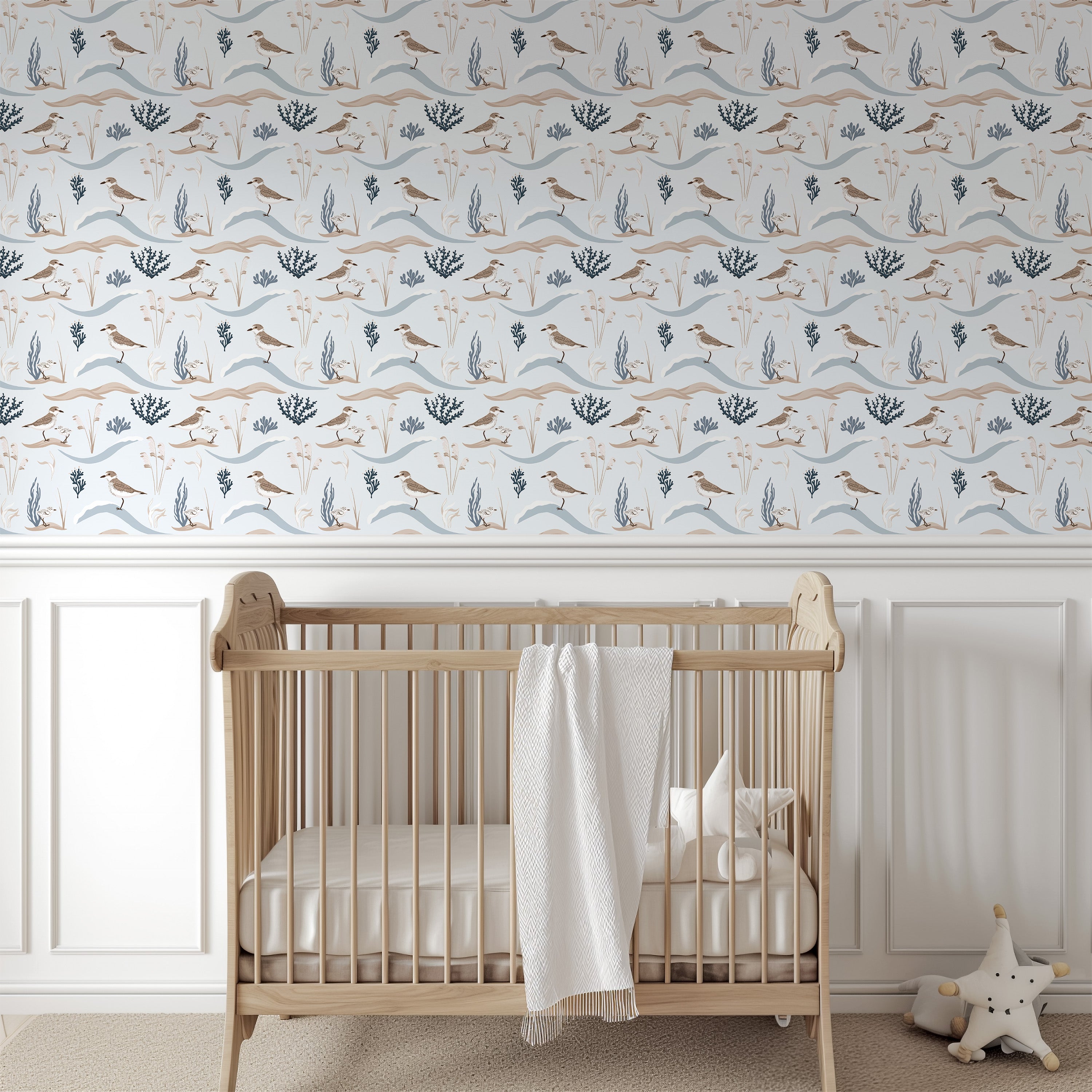 Nursery room with wooden crib and decorative wallpaper featuring birds and plants.